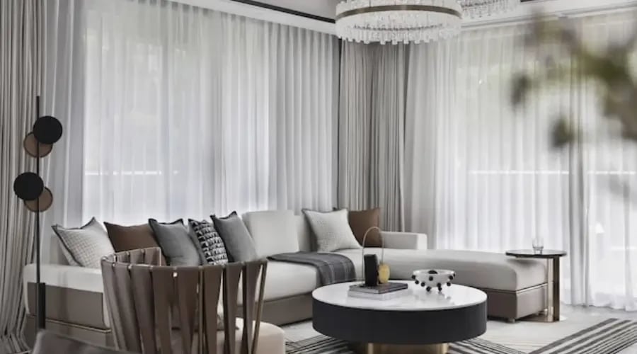 Sophisticated living room with neutral beige and gray curtains, creating a calm and airy atmosphere with soft natural light.