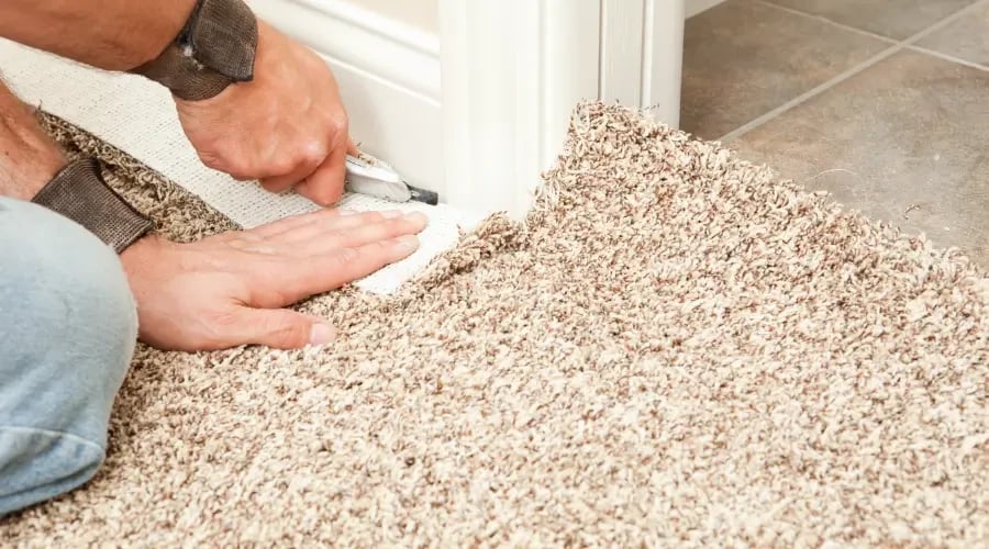 Installing custom wall-to-wall carpet with precise trimming for a seamless home finish.