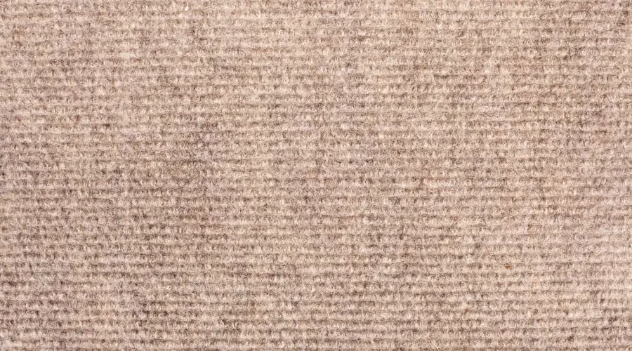 Close-up of custom carpet with loop pile texture in a neutral beige color.