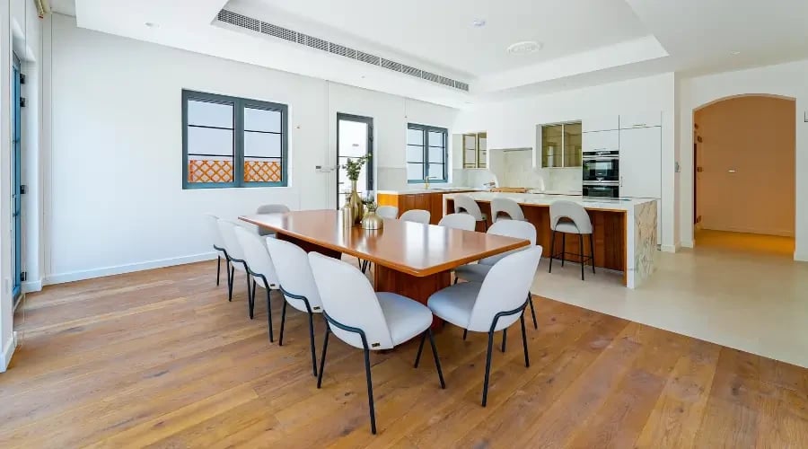Sleek modern dining room design furniture with a wooden dining table and minimalist chairs in an open-plan contemporary villa