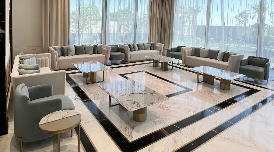 Luxury modern majlis design with custom sofas, marble coffee tables, and elegant floor inlay, crafted for upscale residential interiors in the UAE