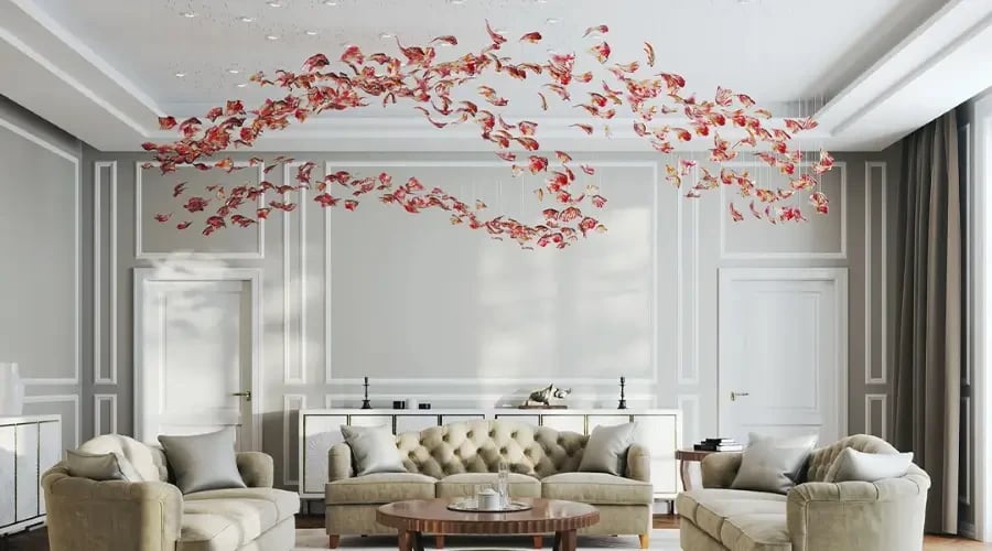 uxury living room with tufted sofas and artistic ceiling chandelier featuring red sculptural leaves
