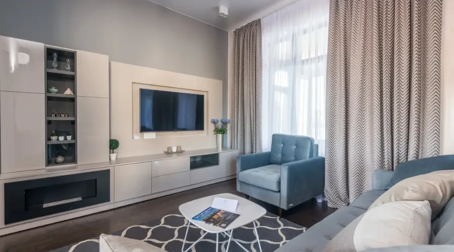Modern living room with textured zigzag print curtains, complementing minimalist furniture and a light-filled space.