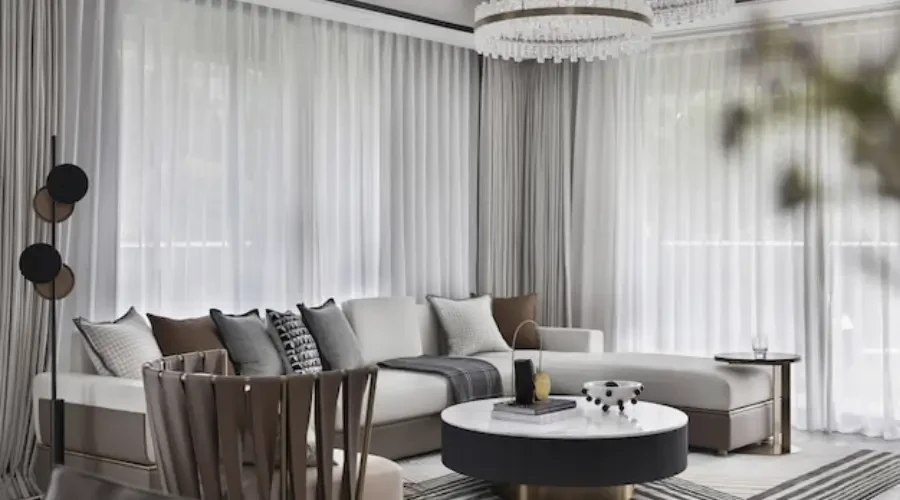 Sophisticated living room with neutral beige and gray curtains, creating a calm and airy atmosphere with soft natural light.
