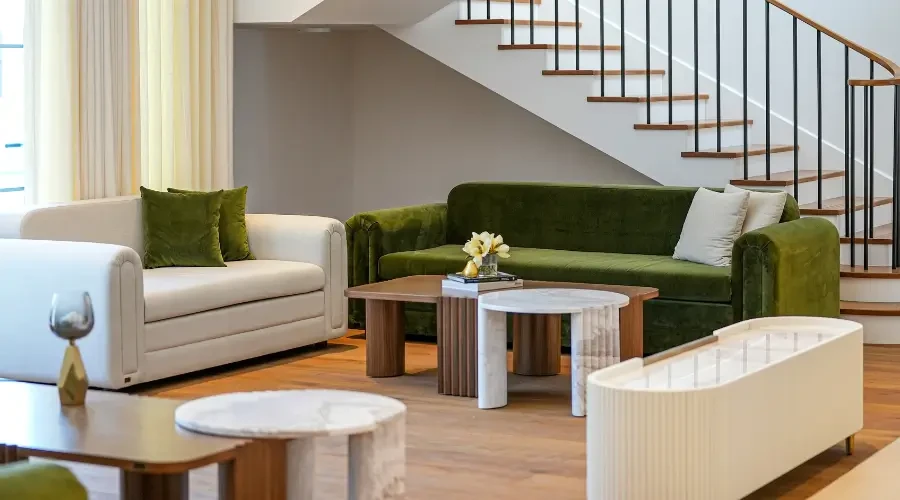  Modern living room furntiure- dubai including Modern living room with green velvet sofas, minimalist coffee tables, and neutral curtains, creating a stylish and inviting space.