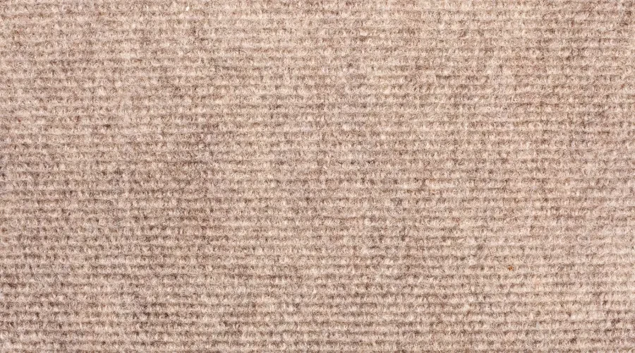 Close-up of custom carpet with loop pile texture in a neutral beige color.