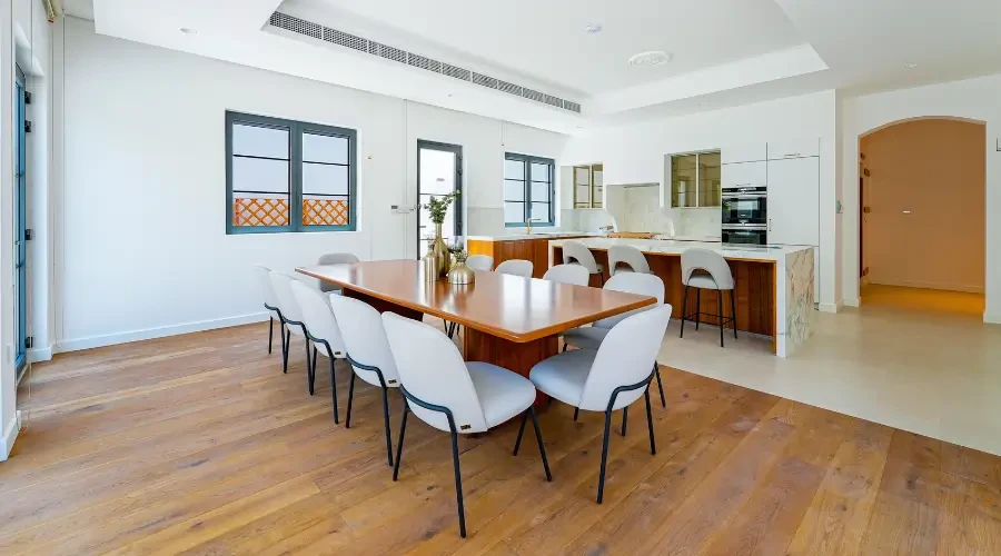 Sleek modern dining room design furniture with a wooden dining table and minimalist chairs in an open-plan contemporary villa
