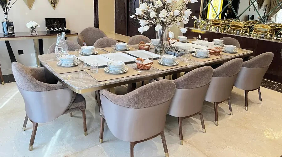 Modern dining room design furniture featuring a luxury marble-top table and custom upholstered chairs in a classic elegant interior